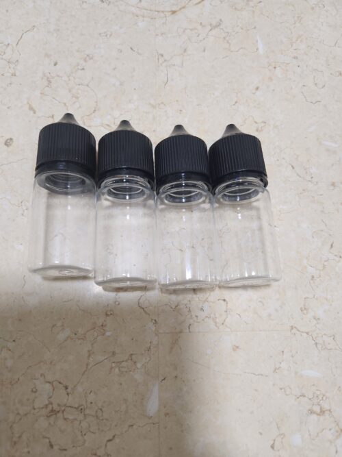 20260420_011916 - Tradedubai.ae Wholesale B2B Market Four empty glass dropper bottles with black caps lined up on a beige marble surface. - Tradedubai.ae Wholesale B2B Market