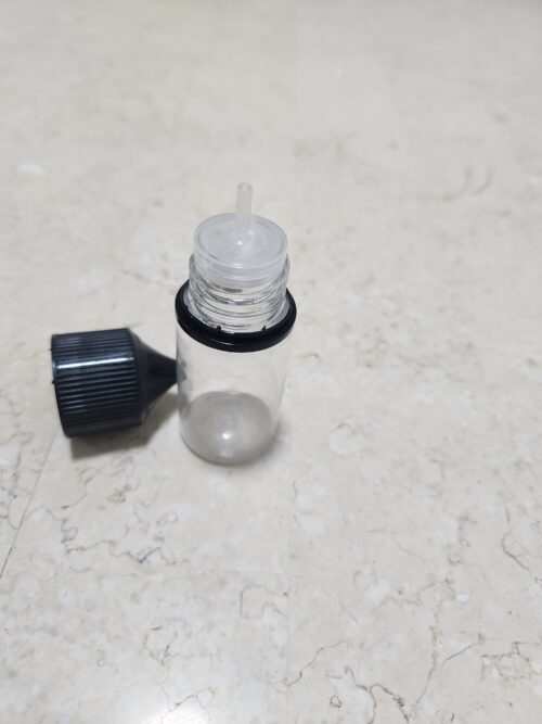 20260420_012007 - Tradedubai.ae Wholesale B2B Market Clear glass dropper bottle with its black cap removed, exposing a plastic dropper, placed on a light marble surface; bottle appears empty. - Tradedubai.ae Wholesale B2B Market