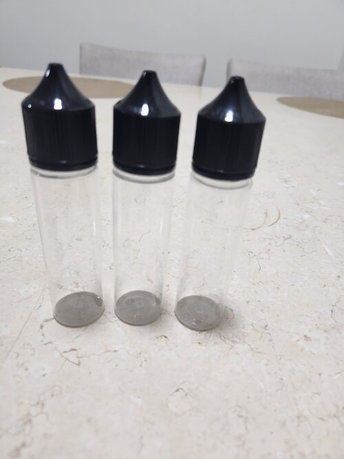 20260420_012038 - Tradedubai.ae Wholesale B2B Market Three empty clear plastic bottles with black screw-on caps on a light countertop. - Tradedubai.ae Wholesale B2B Market