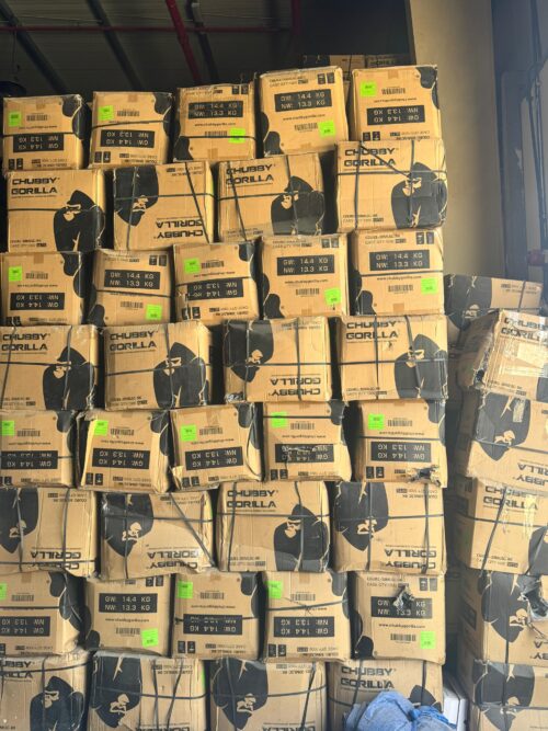 IMG-20260420-WA0013 - Tradedubai.ae Wholesale B2B Market Stacks of Chubby Gorilla cardboard boxes with black gorilla logos and bright green labels in a warehouse storage area. - Tradedubai.ae Wholesale B2B Market